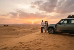 Evening desert safari in Dubai with 4x4 vehicle overlooking golden dunes at sunset